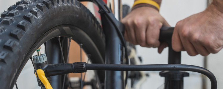 person pumping up bicycle tyre