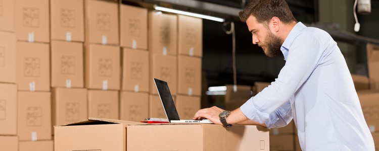 man working on laptop in warehouse