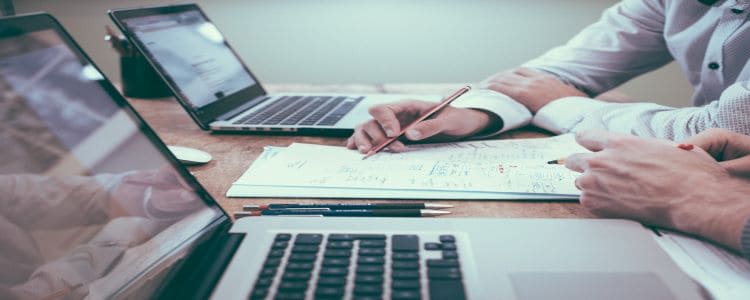 two people with laptops working on accounts