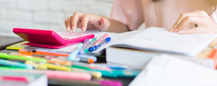 woman using calculator to do end of year accounts