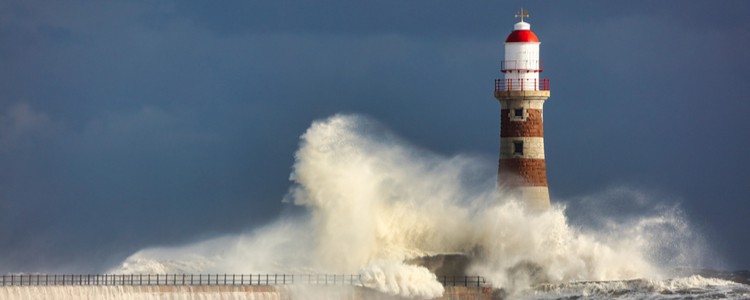 waves crashing against a lighthouse in a storm