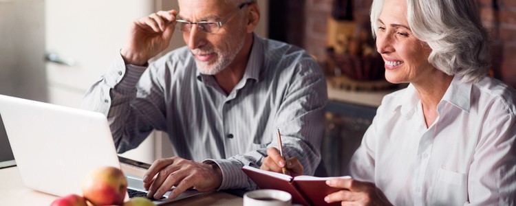 An older couple doing research on a laptop