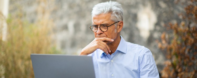 businessman sitting outside with laptop