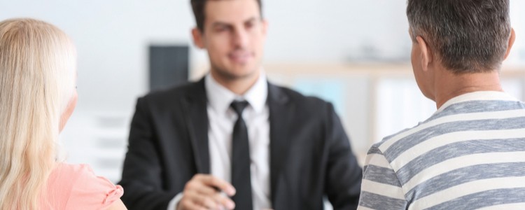 couple sitting across a desk from a solicitor