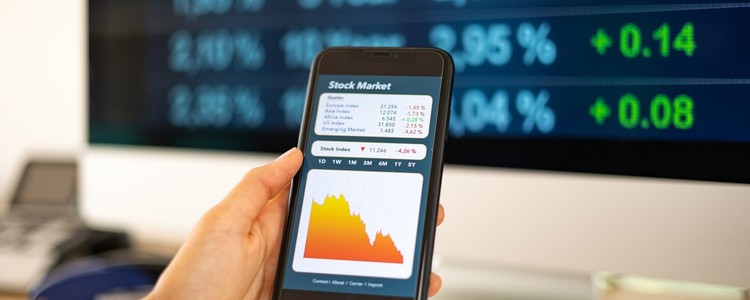 woman holding smartphone showing a graph representing a fall in the stock market