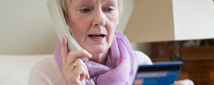 Senior woman giving card details over the phone