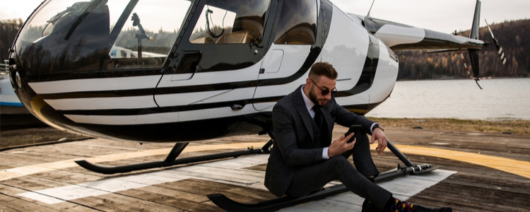 young businessman in suit next to helicopter