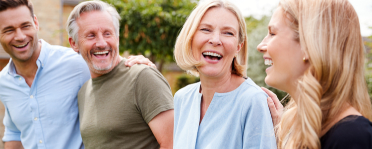 parents and adult children sitting in the garden, laughing