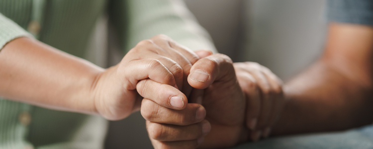 Someone holding another’s hand in a gesture of support