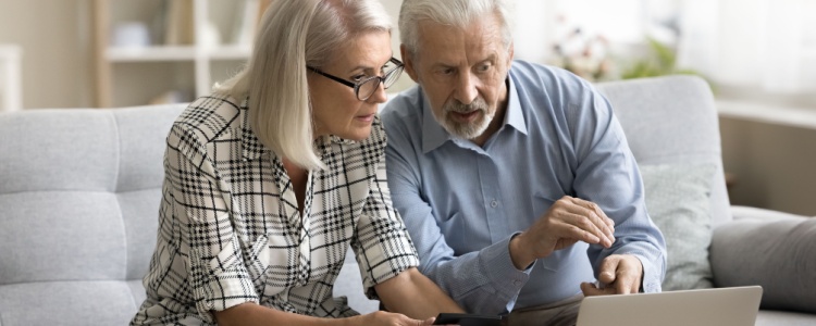 Senior couple reviewing finances on laptop