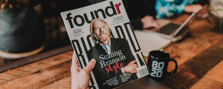 a person holding a magazine with Richard Branson on the cover
