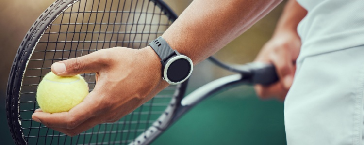Tennis player holding racket and ball