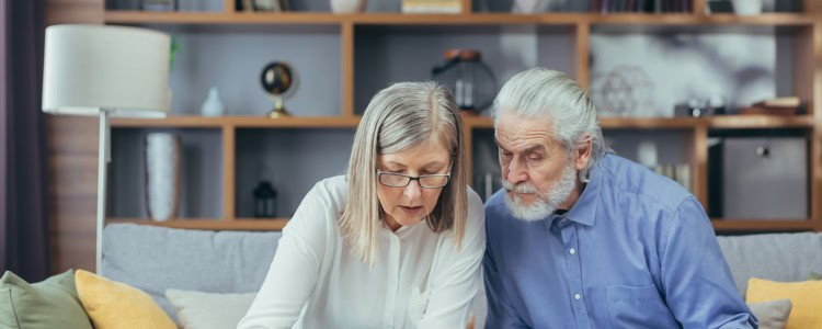 A senior couple looking at documents and using a calculator